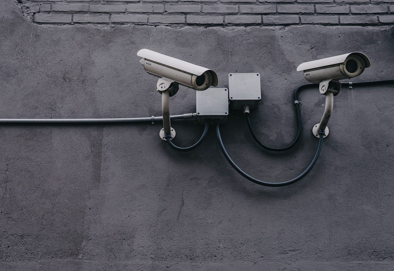 Image of two CCTV cameras with wires that make it look like a smiling face