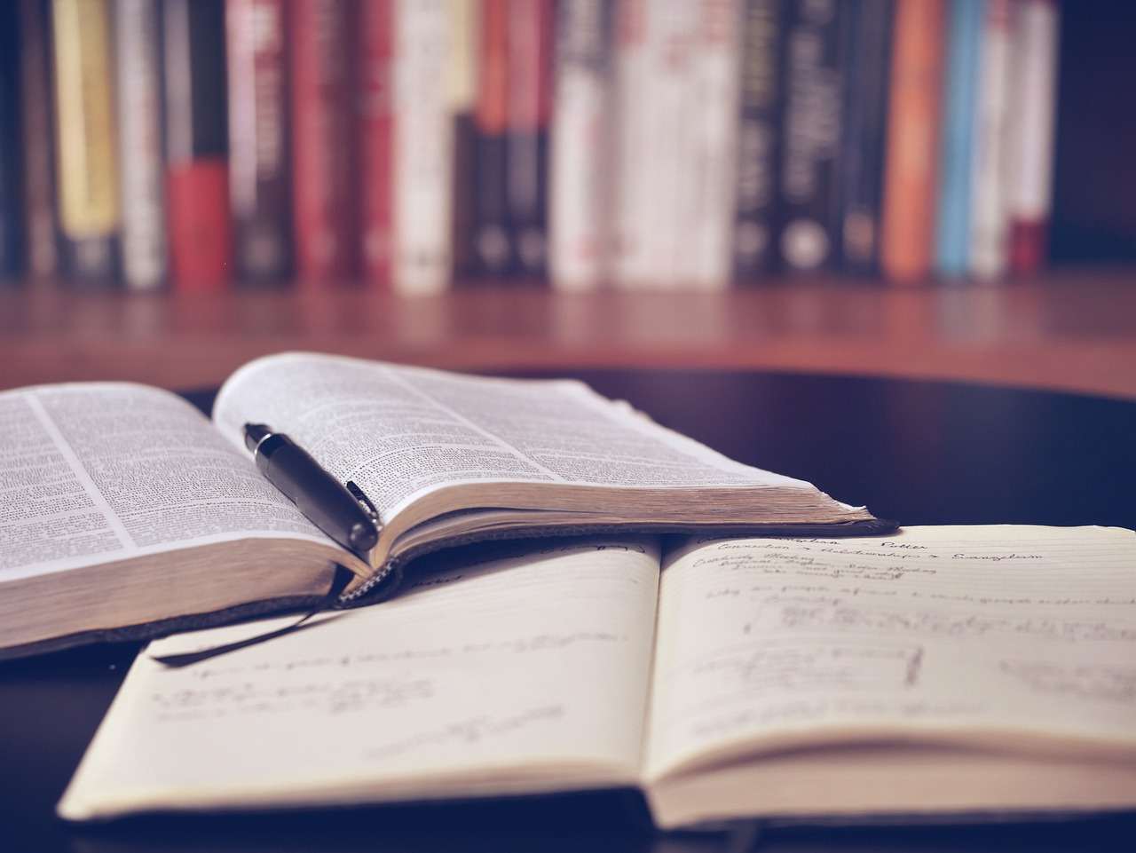 Image of a set of open books and a pen